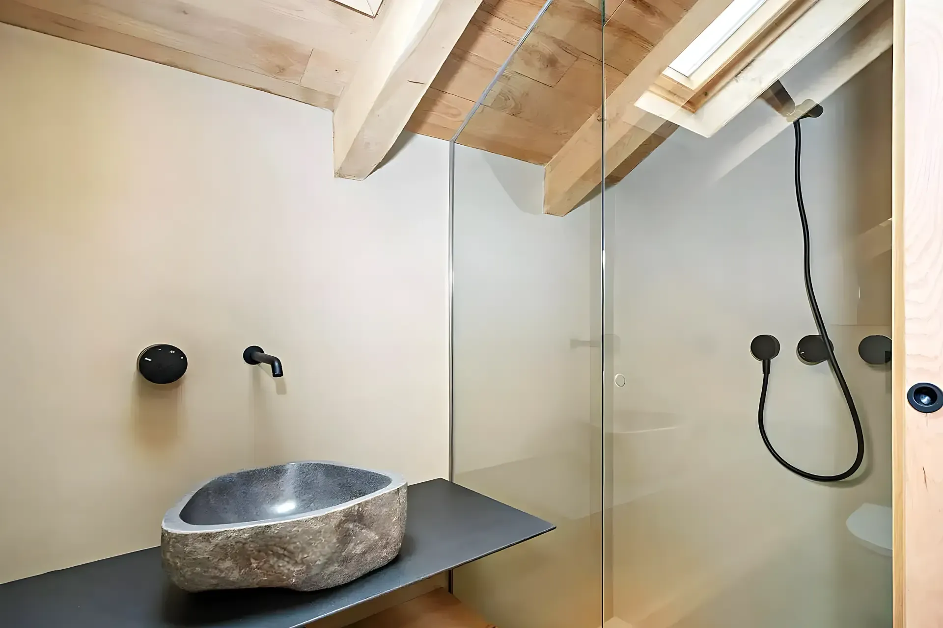 Vasque en pierre naturelle sur tablette en acier noir avec puits de lumière et plafond en bois