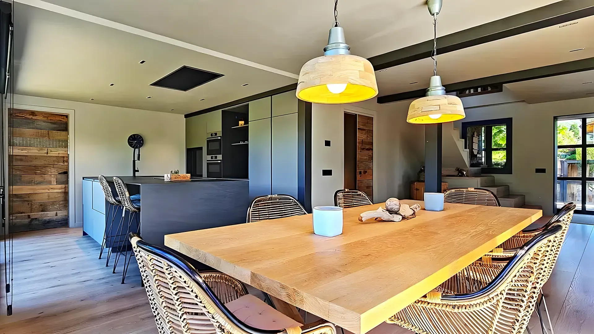 Cocina abierta con mesa de roble macizo y lámparas industriales