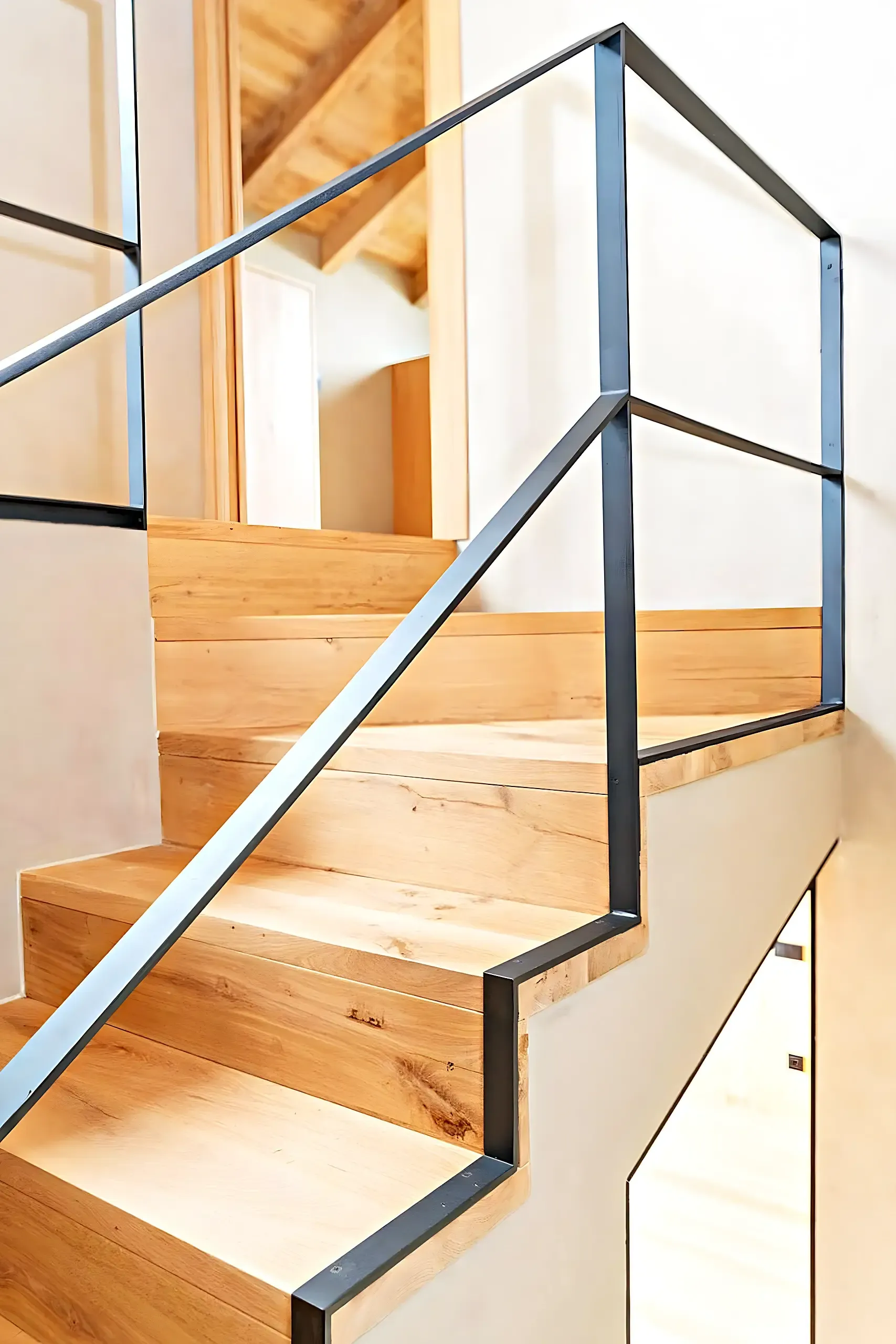 Staircase detail with solid oak treads and a black steel balustrade