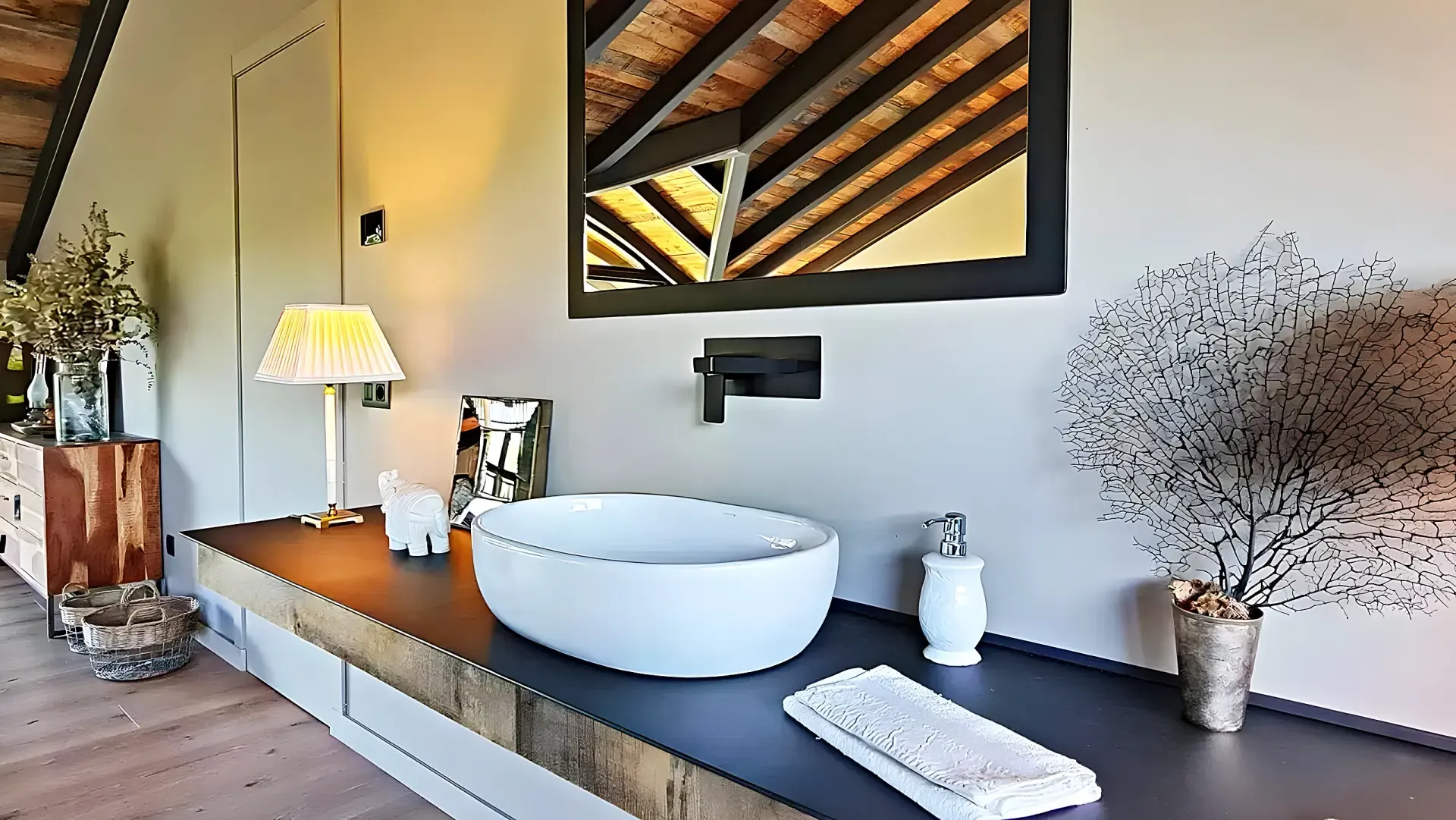 Washbasin detail with a white ceramic bowl on a dark counter and a timber ceiling reflected in the mirror