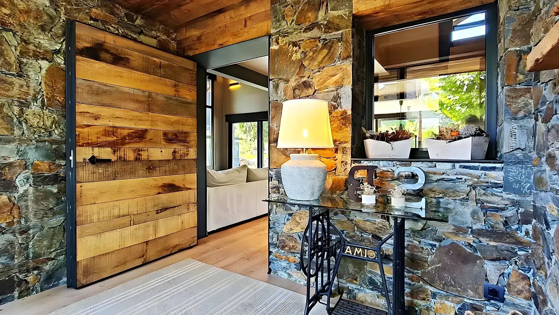 Entrance hall with exposed stone walls, a reclaimed timber pivot door and a singular piece of furniture